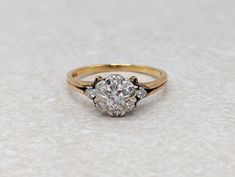 a diamond ring with three stones on the top and bottom, sitting on a white surface