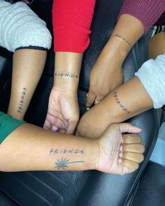 three people holding hands with tattoos on their arms and the words friends written on them