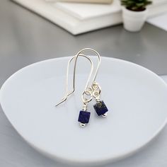 Unleash your daring side with our Cube - Small Lapis Lazuli & Silver Earrings! These dainty sterling silver earrings feature small lapis lazuli gemstone cubes, adding a touch of bold sophistication to any outfit. Tarnish Resistant .940 Sterling Silver Approximately 1.25" long Genuine Lapis Lazuli Gemstone Sent in a Ribboned Gift Box with Polishing Cloth Handmade in Montana Silver Threader Earrings, Threader Earrings Gold, Luxe Jewelry, Lapis Lazuli Gemstone, Studded Necklace, Threader Earrings, Precious Jewelry, Boho Jewelry, Lapis Lazuli