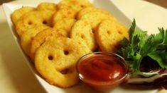 some onion rings are on a plate with ketchup and parsley next to it