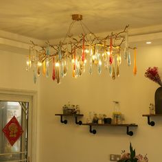 a chandelier hanging from the ceiling in a room with shelves and vases