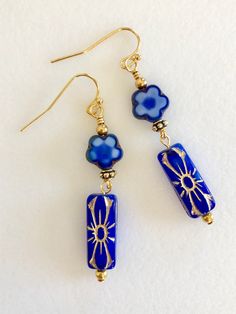 "Stunning deep sapphire blue Czech flower beads with golden bronze details. 20 x 8 mm pressed glass rectangles. Wire wrapped with 10 mm blue Czech glass posies and antique gold bead accents. Gold plated French ear hooks. Total drop 2\"." Nickel Free Blue Rectangular Jewelry, Sapphire Blue Earrings, Czech Glass Jewelry, Dark Blue Flowers, Jewelry Chest, Aquamarine Earrings, Jewelry Accessories Ideas, Jewelry Design Earrings, Earrings Inspiration