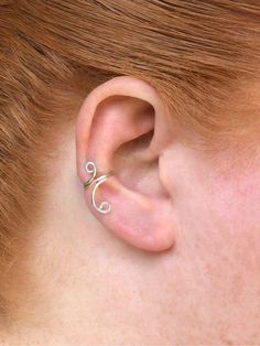 a close up of a person with a ear piercing in the shape of a wave