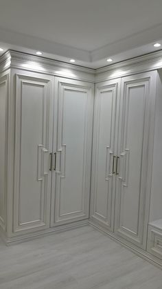 an empty room with white closets and drawers in the corner, all lined up