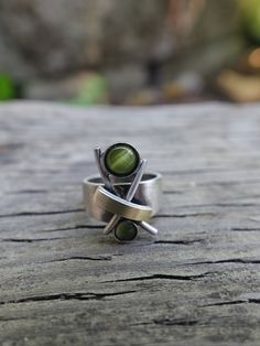 Vintage women's modernist ring in a unique and flattering design.  With green stones and brushed metal and copper look this one is so unique!  Artisan made and would make a lovely gift.  Size 9. Will fit pointer finger on a medium hand. Green Open Ring Made Of Metal, Green Metal Open Ring, Modernist Green Jewelry For Gifts, Unique Green Metal Ring, Green Metal Rings For Anniversary, Green Metal Anniversary Rings, Minimalist Green Metal Jewelry, Green Minimalist Metal Jewelry, Modernist Green Ring As A Gift