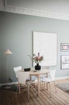 a dining room table with chairs and pictures on the wall above it, along with a rug