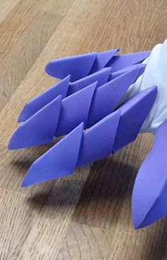 an origami bird made out of blue and white paper on a wooden table