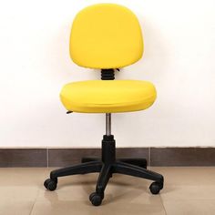 a yellow office chair sitting in front of a white wall