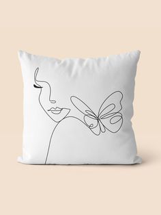 a white pillow with a black line drawing of a woman's face on it