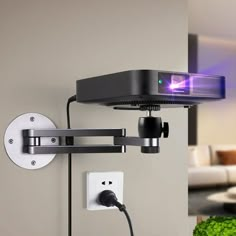 a wall mounted projector is plugged into the side of a wall with an outlet