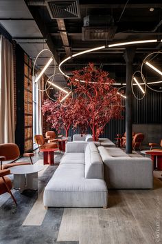 a living room filled with lots of furniture next to a tall tree in the middle