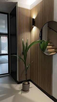 a potted plant sitting on top of a white table next to a round mirror