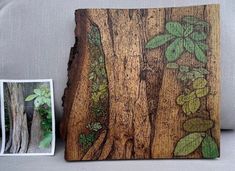 a wooden plaque with green leaves on it next to an old photo frame and tree stump