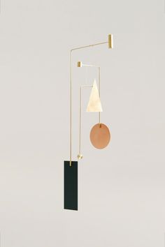 a mobile with two different shapes hanging from it's sides and a circular object on the other side