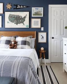 a bed room with a neatly made bed and pictures on the wall