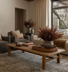 a living room with couches, chairs and a coffee table in front of a large window