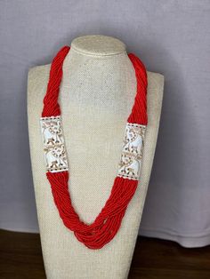 A beautiful multi layered red beaded necklace with shell pendants on two sides. The shell is intricately designed to give a ethnic look. Traditional Multi-strand Red Coral Beaded Necklace, Traditional Red Coral Beaded Necklace With Colorful Beads, Traditional Red Beaded Necklace With Wooden Beads, Festive Red Coral Necklace, Traditional Multi-strand Red Coral Necklaces, Traditional Multi-strand Red Coral Necklace, Traditional Multi-strand Wooden Bead Necklaces, Traditional Multi-strand Beaded Necklaces For Festive Occasions, Traditional Multi-strand Beach Jewelry