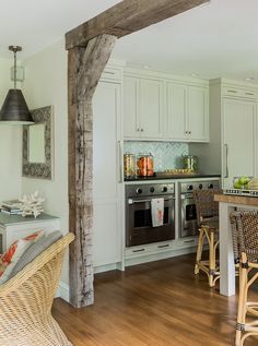 a kitchen with white cabinets and wood flooring next to an island in the middle