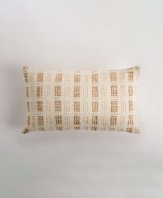 a white and brown pillow sitting on top of a table