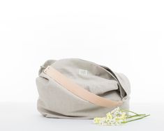 "This beige hobo bag is super lightweight. It's a shoulder purse so comfortable that you won't want to take it off. Also, the wide leather handle does not stick to your shoulder. This shoulder bag is lined with a pink and white striped fabric 100% cotton. Its 100% linen outer fabric is very cool and pleasant for the summer. This spacious, comfortable and lightweight hobo bag is perfect for any time of day and adds style to any outfit. * Materials: - Outside: 100% stonewashed linen. Beige color - Eco-friendly Beige Hobo Bag For Spring, Eco-friendly Hobo Bag With Leather Handles For Travel, Eco-friendly Hobo Bag For Travel With Leather Handles, Spring Beige Hobo Bag Tote, Beige Spring Hobo Tote Bag, Beige Hobo Tote Bag For Spring, Beige Tote Hobo Bag For Spring, Beige Bags With Soft Interior For Daily Use, Beige Weekender Bag For Everyday Use