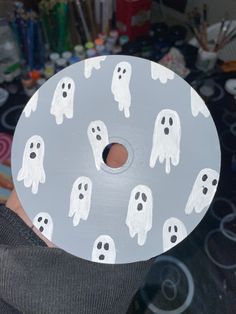 a person holding up a paper plate with ghost faces on it