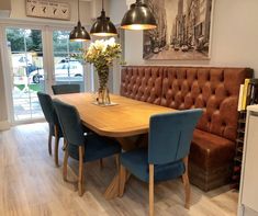 a dining room table with blue chairs and a brown bench