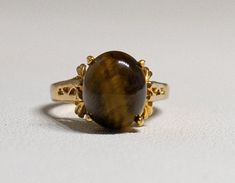 Beautiful Vintage Ring with Large Tiger's Eye gemstone This is an HGE (Heavy Gold Electroplated) ring. Hallmarked DO 18Kt HGE Size 5 in perfect vintage condition no tarnish The ring will arrive in a gift box! Please feel free to look at the other items I hope and believe you will find something else that will like and interest you. My Store https://www.etsy.com/shop/Jelifem Tiger Eye Engagement Ring, Tigers Eye Rings, Tigers Eye Ring Gold, Tigers Eye Ring, Beautiful Rings Vintage, Gold Tiger Eye, Tigers Eye Gem, Tiger Eye Gemstone, Tiger Eye Jewelry