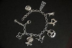 A collection of silver plated Texas themed charms have been dispersed around a shimmering silver plated bracelet chain in this handmade charm bracelet. This Texas charm bracelet is then completed with a lobster clasp and a 1/2 inch of chain at the end for adjustable sizing. Charms in this bracelet include two Texas state charms, a lone-star charm, an oil rig charm, bull charm, Texas rose charm, boot spurs charm, horseshoe with cowboy boots charm, and a long horn charm. ● Sizing ● To determine yo Personalized Symbolic Silver Bracelets, Silver Symbolic Bracelets With Dangling Charms, Symbolic Silver Bracelets With Dangling Charms, Symbolic Silver Bracelets With Charms, Symbolic Silver Bracelet With Dangling Charms, Symbolic Sterling Silver Charm Bracelet, Silver Symbolic Charm Bracelet Hypoallergenic, Symbolic Silver Hypoallergenic Charm Bracelet, Silver Adjustable Chain Bracelet With Dangling Charms