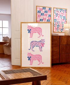 two pink and blue tiger prints are on display in a room with wooden floors, white walls and wood flooring