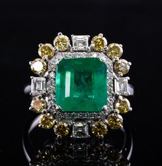 This stunning estate ring is crafted in solid 18K White Gold
The center natural Earth mined Zambian Emerald measures 9x8.5mm (appr. 3.10 carats by calculation).
This is a gorgeous vivid color stone.
It is accented with 30 round brilliant cut diamonds (.30 carat of VS2-SI1 clarity and H color).
2 square and 2 emerald cut diamonds total .60 carat of VS1 clarity and H color.
12 canary diamonds total 1.20 carats of VS1 clarity.
The total diamond weight for the ring is 2.10 carats. Gia Certified Yellow Gold Cluster Ring, Gia Certified Luxury Diamond Ring For Collectors, Exquisite Gia Certified Cluster Ring, Luxury Gia Certified Collectible Diamond Ring, Luxury Collectible Gia Certified Diamond Ring, Gia Certified Diamond Rings For Collectors, Collectible Gia Certified Yellow Gold Rings, Luxury Cluster Emerald Ring In Yellow Gold, Luxury Yellow Gold Cluster Emerald Ring