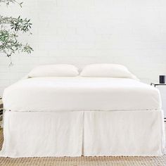 the bed is made with white linens and pillows