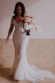 a woman in a wedding dress holding flowers