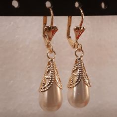 A nice edition to your jewelry set, this pair of earrings is larger than perceived, the droplet hangs low and makes a statement by the wearer. The laminated section holding the pearl has a design as well, this section glimmers once exposed to the sun. Details Laminated gold Pearl droplet design Elegant Jewelry With Teardrop Crown Matching Earrings, Elegant Teardrop Crown Matching Earrings Jewelry, Elegant Jewelry With Matching Teardrop Crown Earrings, Teardrop Metal Jewelry For Evening, Drop Pearl Pendant Jewelry For Evening, Pearl White Teardrop Jewelry For Evening, Evening Teardrop Metal Jewelry, Gold Teardrop Jewelry With Pearl Drop, Gold Dangle Earrings With Pearl Drop