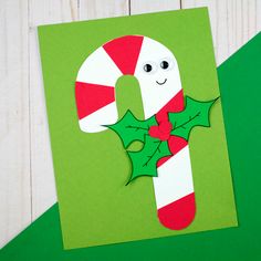 a candy cane with holly leaves on it is cut out to look like a letter