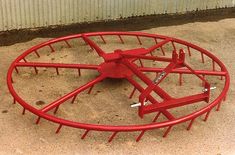 a large red metal object sitting in the sand