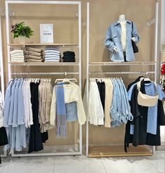 a clothing store display with clothes on racks and hangings in front of the rack