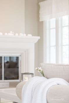 a living room filled with furniture and a fire place in front of a white fireplace