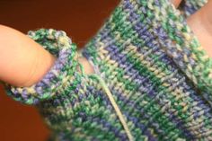 someone is holding their hand out to show the stitchs on this knitted fingerless glove