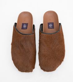 This signature pair of clogs is made by hand at our atelier from surplus cowhide leather from fashion industry. They feature a cork bed molded to the shape of your foot, a suede upper lining, a leather trim and a durable rubber sole. Our clog design is inspired by the late-13th and early-14th century original shoes worn by peasants and lower classes in Europe. Read the history of the clog on our journal. They are inspired by a visit to Istanbul in 2013—read about our travels the history of kilim on our journal. One-of-a-kind100% natural cowhideCork foot bed molded to the shape of your footSuede upper liningLeather trimDurable rubber soleHandmade in Marrakech Pair with Puffer Vest and Vintage 501 Denim Women’s Sizing US EU UK 6 / 6 1/2 36 4 7 / 7 1/2 37 5 8 / 8 1/2 38 6 9 / 9 1/2 39 7 10 / Cork Bed, Cowichan Sweater, Kimono Outerwear, Crochet Pants, Limited Edition Shoes, Denim Hat, Backpack Tote Bag, Velvet Pillow Covers, 14th Century