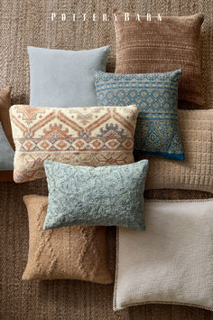 a collection of decorative pillows on a couch