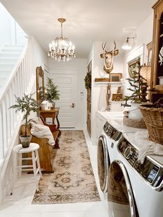 a washer and dryer sitting in a room next to a staircase leading up to a kitchen