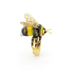 a yellow and black bee ring sitting on top of a white surface