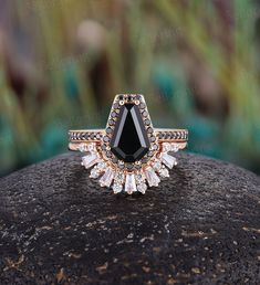 a black diamond ring sitting on top of a rock