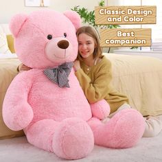 a girl is hugging a large pink teddy bear