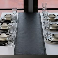 the table is set with black and white plates, silverware, and glassware