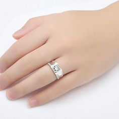 a woman's hand wearing a ring with a diamond on the middle and side