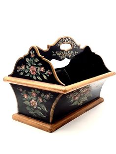 a black and gold flowered box with wooden handles