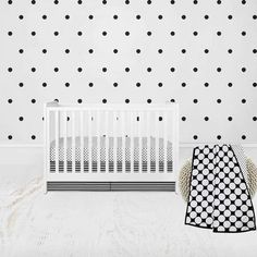 a white crib and black polka dot wall decals