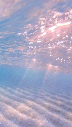 the sun shines through the water as it reflects on the sandy bottom of the ocean