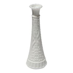 a white ceramic vase with an intricate design on the top and bottom, sitting in front of a white background